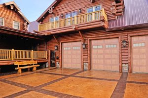 A cabin-style home with wood-tone garage doors