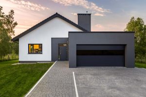 A modern industrial style home with a black garage door